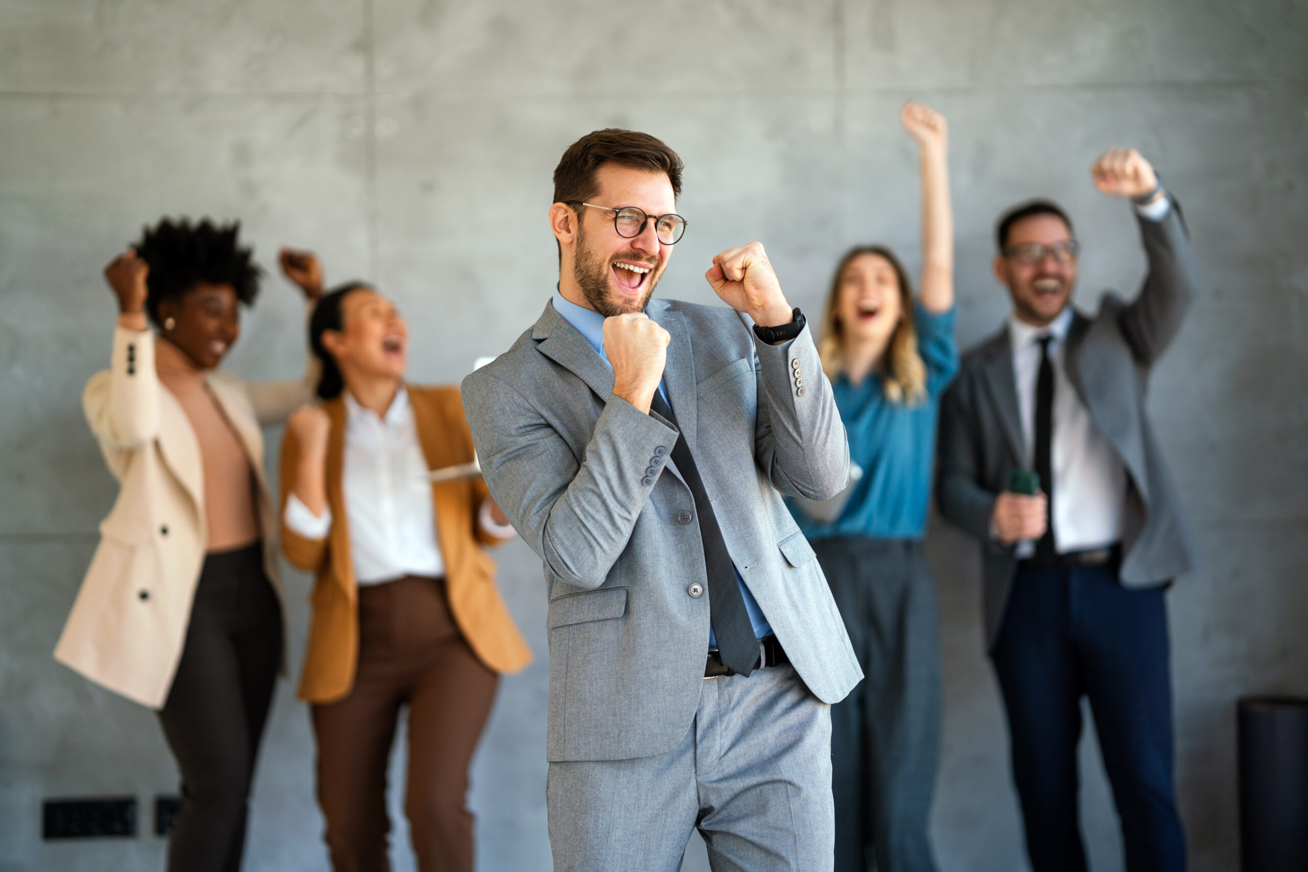 A group of business professionals celebrating success in the office.
