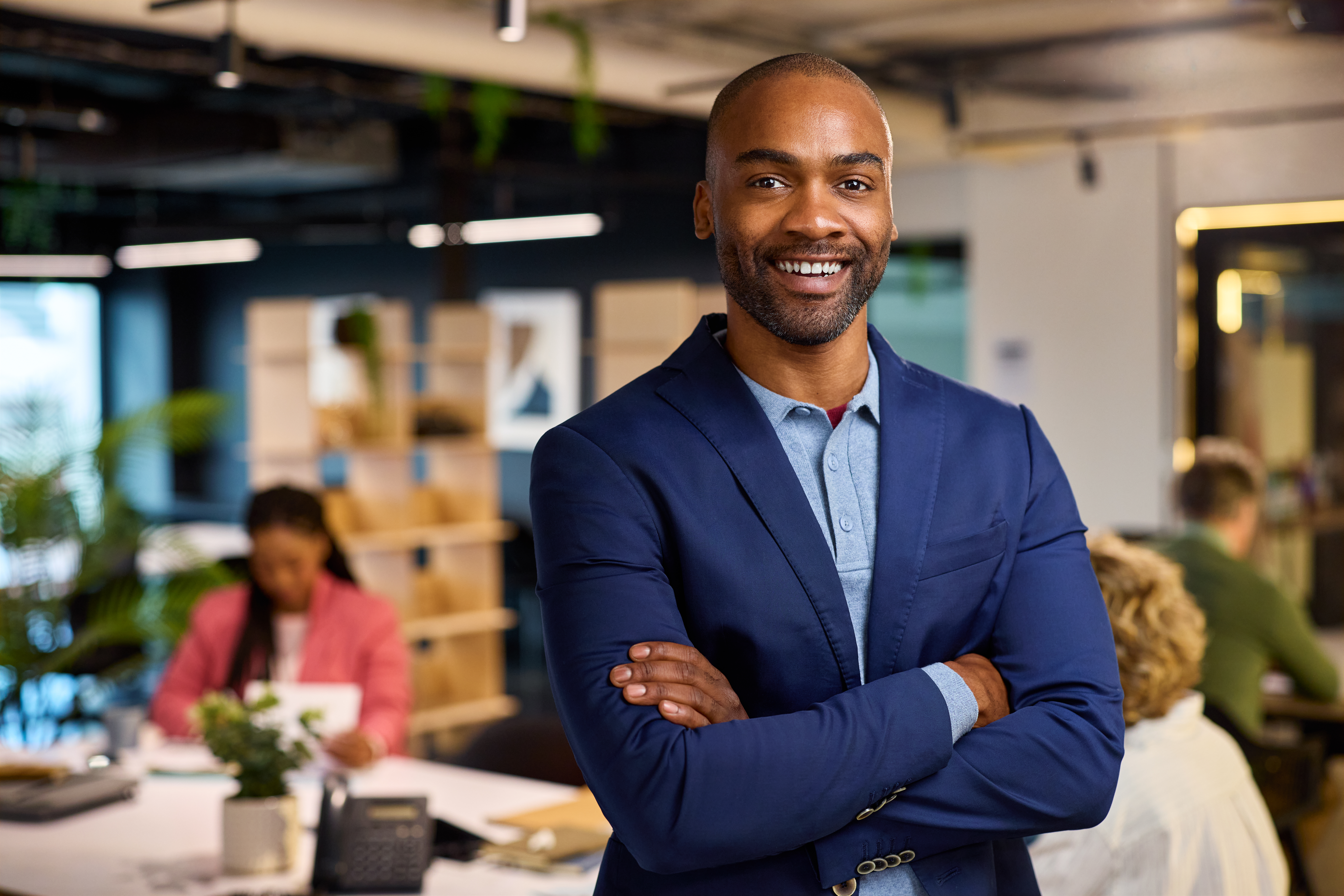 A smiling young professional standing in a cozy office setting